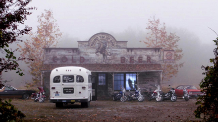 Church bus in front of the biker bar as the angels kill each other in the window.